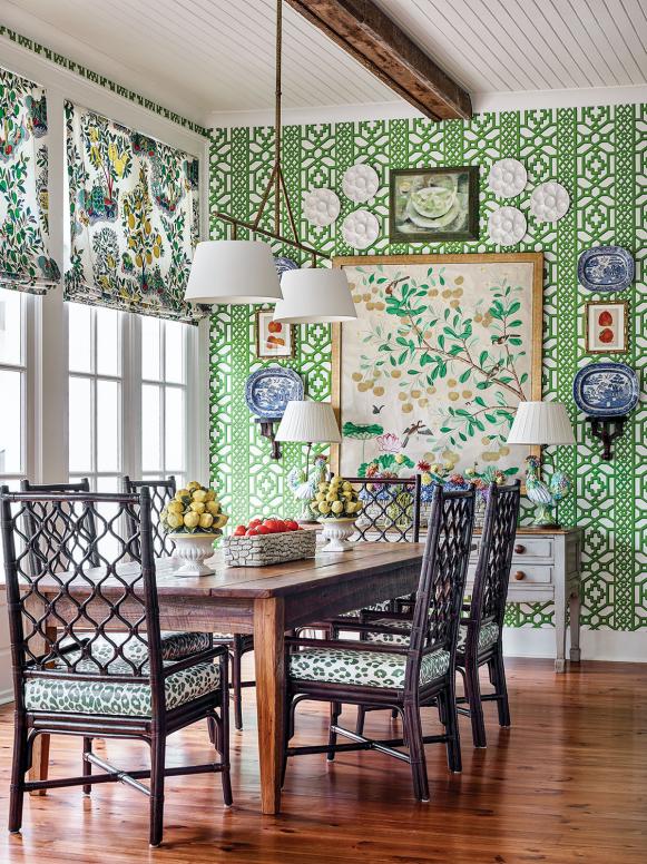 Bold green and white wallpaper surrounds a dining table.