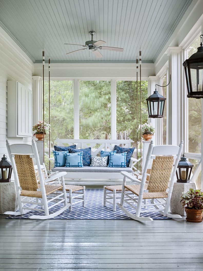 A wide screened porch features rockers and a large hanging swing.