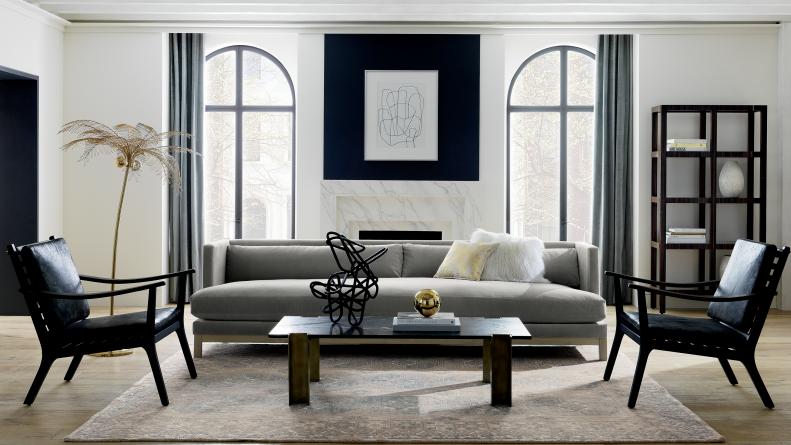 Tall arched windows frame a black, white, and grey living room. 