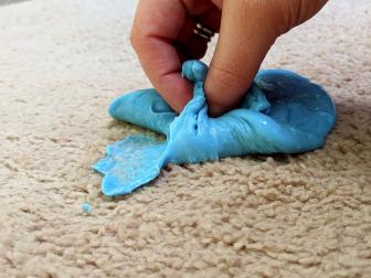 Homemade slime is pulled from beige carpet before a cleaner is applied