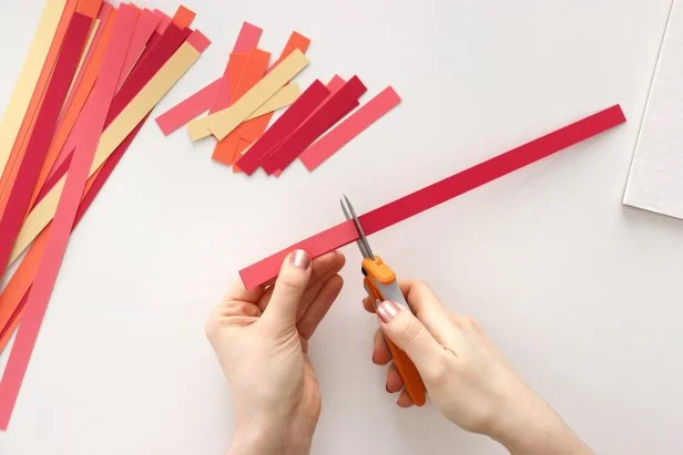 Cut cardstock into ¼” strips using a paper cutter or scissors. Then cut down each strip to pieces that measure 3¼”. Once you have one piece cut, you can use it as a pattern to trim the rest of the strips.