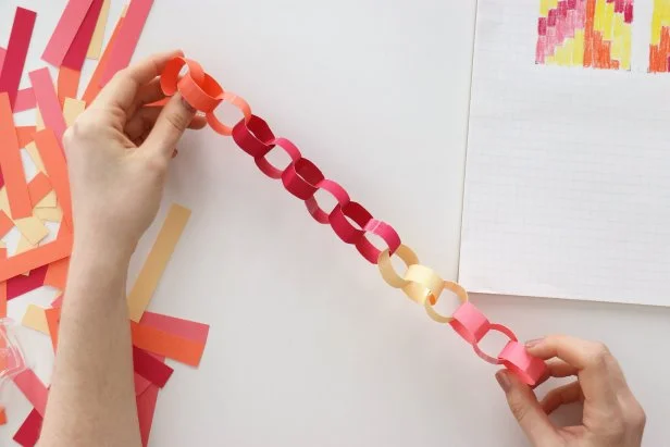 Make paper chains following your pattern by taping one paper strip into a circle and then attaching more circles underneath.
