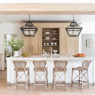 Neutral Kitchen Features a Large Island, Wrought Iron Pendants and Natural Wood Cabinets