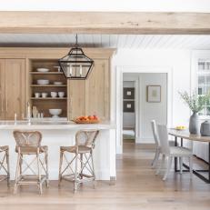 Open Plan Kitchen Features a Large Wood Beam That Compliments the Natural Wood Cabinets and Contrasts the Large White Island
