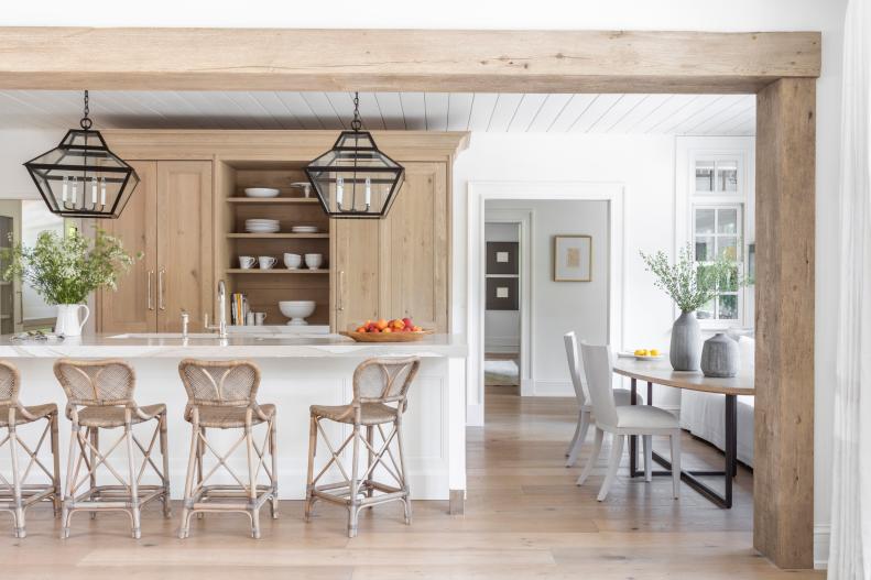 Neutral Kitchen Features a Large Island and Wrought Iron Pendants