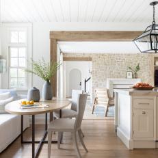 Neutral Dining Nook Features a Small Table and Is Accented With a Wood Door Frame