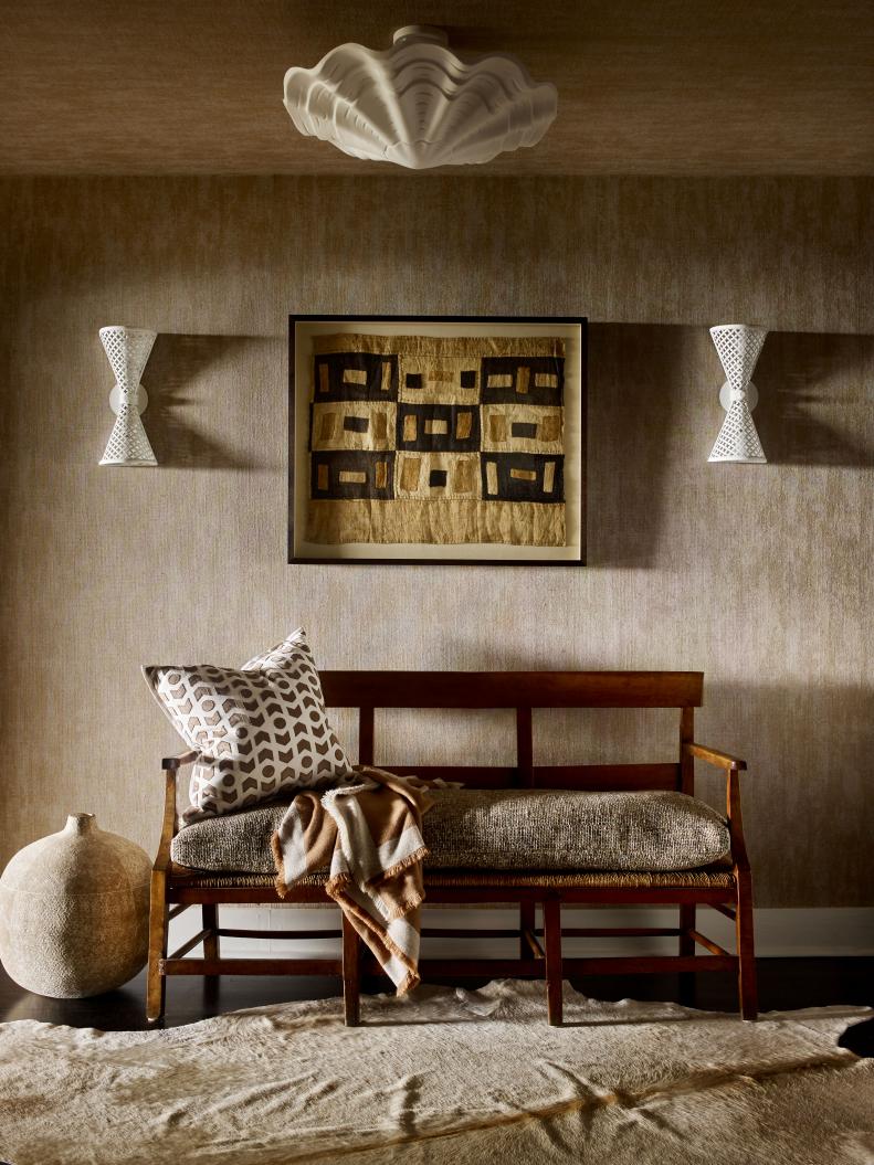 This foyer includes textured wallpaper and a wood bench.