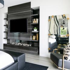 Modern Bedroom Features a Black Stone Fireplace With Built-In Shelves 