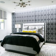 Bright Bedroom Features an Accent Wall a Midcentury Modern Chandelier and a Geometric Patterned Rug