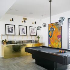 Large Game Room Features a Pool Table, a Modern Chandelier and a Hammered Brass Bar