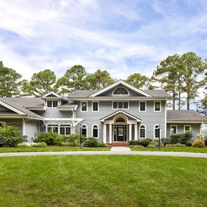 Traditional Home Features Blue and White Siding and a Circle Driveway and Matching Sidewalk