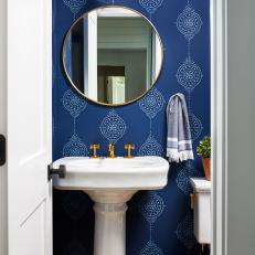 Eclectic Powder Room Features Bold Wallpaper, a Gold Pendant and Matching Mirror and a Pedestal Sink