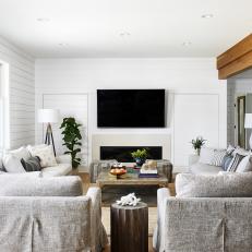 Neutral Living Room Features Wood Beams, Shiplap Walls and a Built-In Fireplace