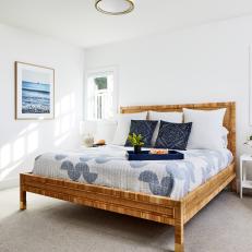 Bright Bedroom Features a Wicker Bed Frame and Blue Decorative Accents