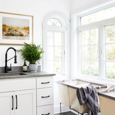 Bright Corner Features a White Cabinet With Gray Countertops and Large Windows