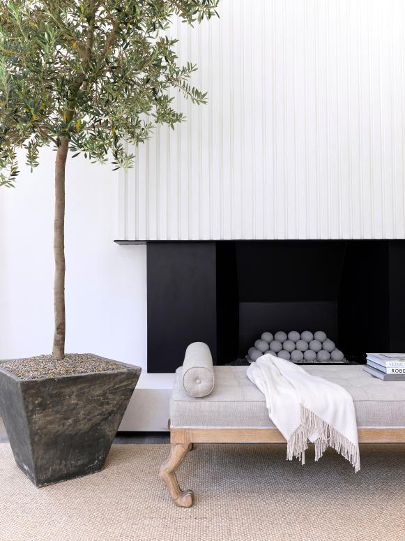 A living room features a white fireplace with a black hearth.