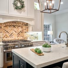 Open Concept Kitchen Features a Brick Backsplash and Shaker-Style Cabinets