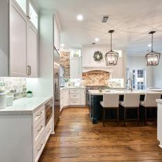 Open Kitchen Features Neutral Cabinets, a Brick Backsplash and a Large Kitchen Island