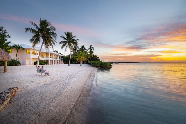 Two People Sit on Beach Watching the Sunset at Florida Keys