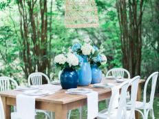 This outdoor wood table includes hydrangea flowers and white linen.