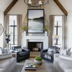 Living Room With Vaulted Ceilings Features a Limestone Fireplace and Wrought Iron Chandelier