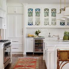 Traditional White Kitchen with Glass-Fronted Cabinets, Marble Island and Rug