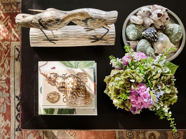 A coffee table features carved birds, shells, and flowers.