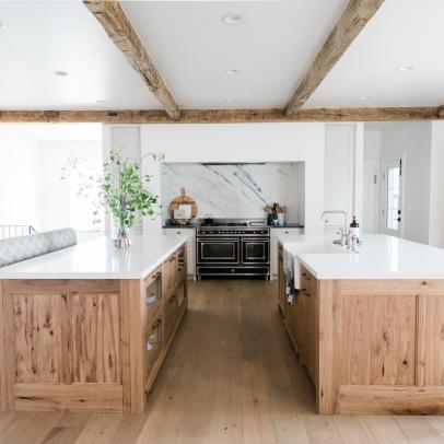 Double Wood Islands Accent a Bright Open Concept Kitchen That Features Exposed Beams