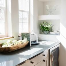 Built-In Shelves Accent a Kitchen Wall Above a Black Stone Countertop