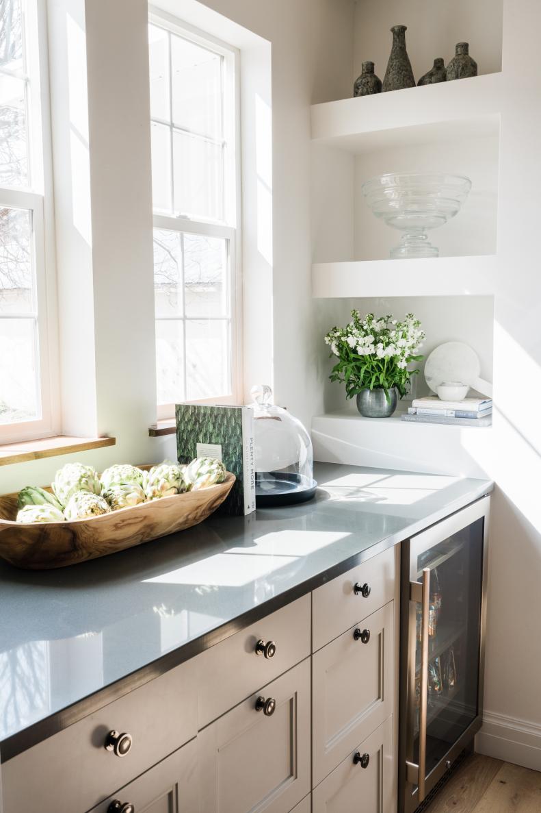 Black Stone Countertops Top Gray Cabinets Next to Built-In Shelves