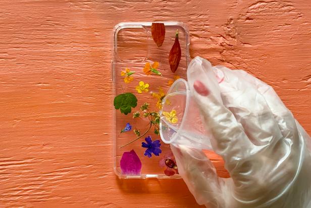 Pour a small amount of resin over the flowers on the cell phone case.