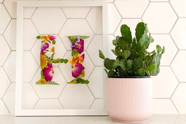 HGTV Handmade’s Liz Gray shares how to make pressed flower, monogram wall art. To make, you will need white tulle, a float frame, printed letter, a low-temp hot glue gun and glue sticks, pressed flowers and scissors.