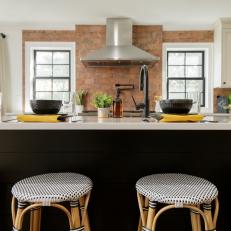 Brick Tile Wall Sets Off Stainless Range Hood in Sharp Black-and-White Kitchen