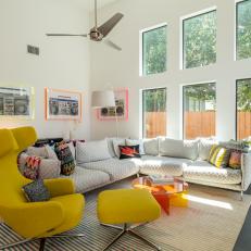 Modern Living Room With Vaulted Ceilings Features a Gray Sectional and a Yellow Chair