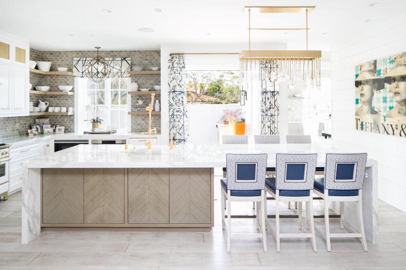 Kitchen Features an Island, a Neutral Backsplash and a Gold Chandelier