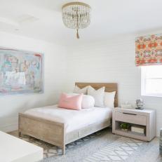 Eclectic Bedroom Features a Wood Bed Frame, a Beaded Chandelier and Patterned Decorative Accents