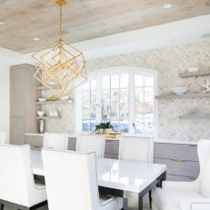 Neutral Dining Room Features a Large Table, a Wallpaper Accent Wall and Built-In Storage Cabinets
