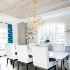 Dining Room Features a Large White and Black Table With Matching Chairs and a Built-In Buffet