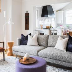 Bright Living Room Features a Gray Sofa, a Purple Ottoman and a Variety of Modern Accents