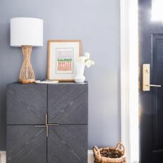 Entryway Features a Modern Cabinet, Topped With a Lamp and Frame
