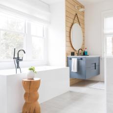 Modern Bathroom Features a Freestanding Square Tub, a Floating Vanity and a Wood Accent Wall