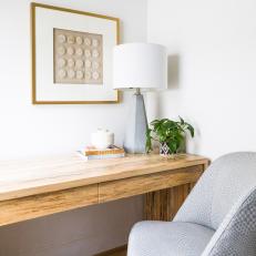 A Bright Corner Home Office Features a Wood Desk and an Upholstered Desk Chair