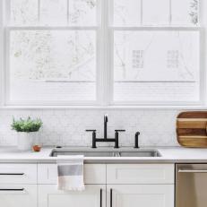 Bright Kitchen Features White Cabinets, a Mosaic Backsplash and Black Fixtures