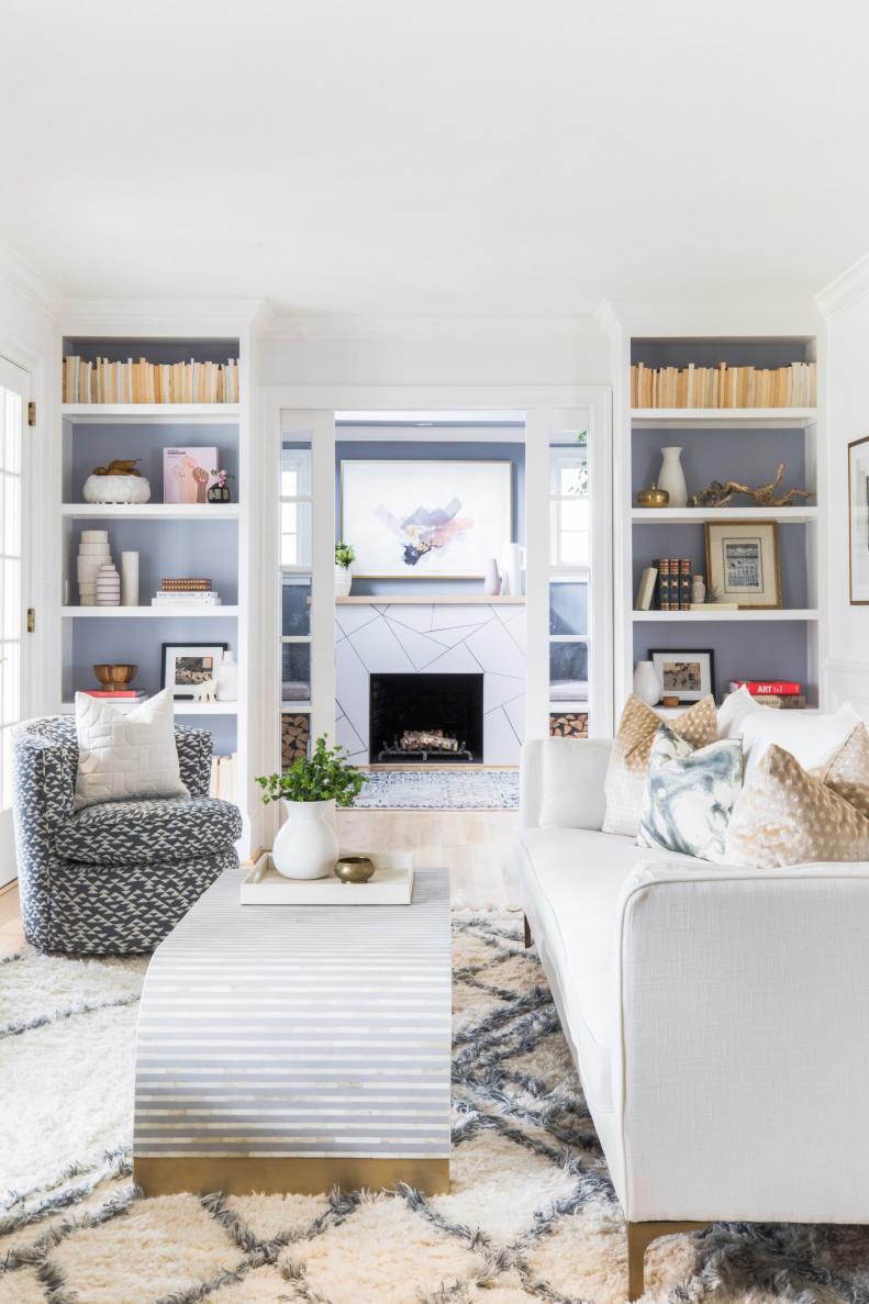 Neutral Living Room Features Built-In Bookshelves and Pocket Doors