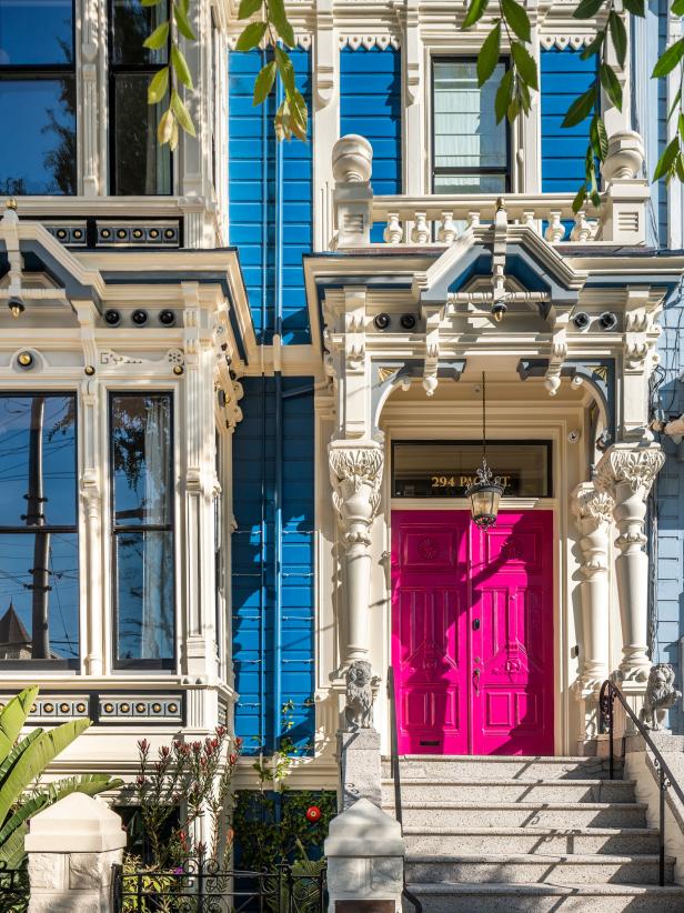 Bright Pink Door and White Molding Accents a Blue Victorian-Style Home
