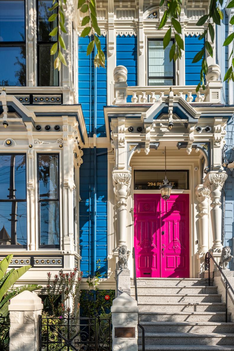 Bright Pink Door and White Molding Accents a Blue Victorian-Style Home