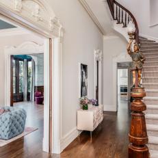 Grand Entryway Features a Spiral Staircase and Traditional Molding 