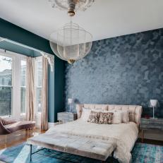 Moody Blue Bedroom Features Geometric Wallpaper and a Modern Chandelier