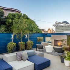 Modern Rooftop Sitting Area Features an Outdoor Fireplace and Potted Plants
