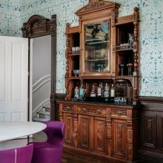 Bright Dining Room Features an Ornate Built-In Bar and Bold Wallpaper